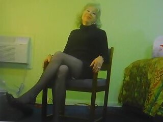 Crossdresser dangles her shoes and poses